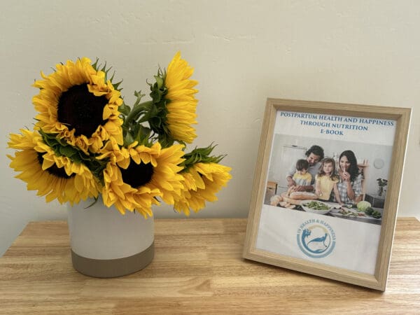 A vase of sunflowers on the table with a picture