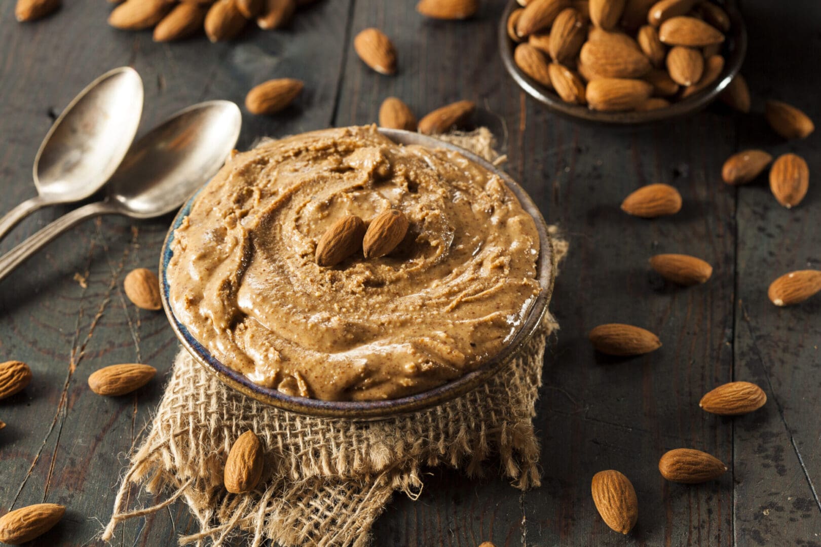 Almond butter in a bowl with almonds.