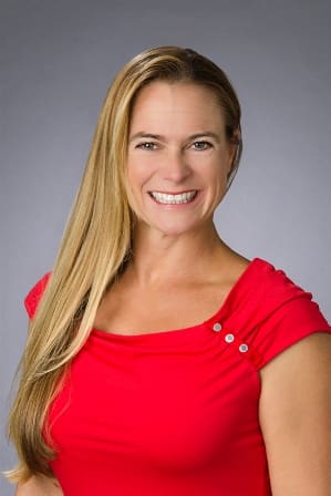 A woman in red shirt smiling for the camera.