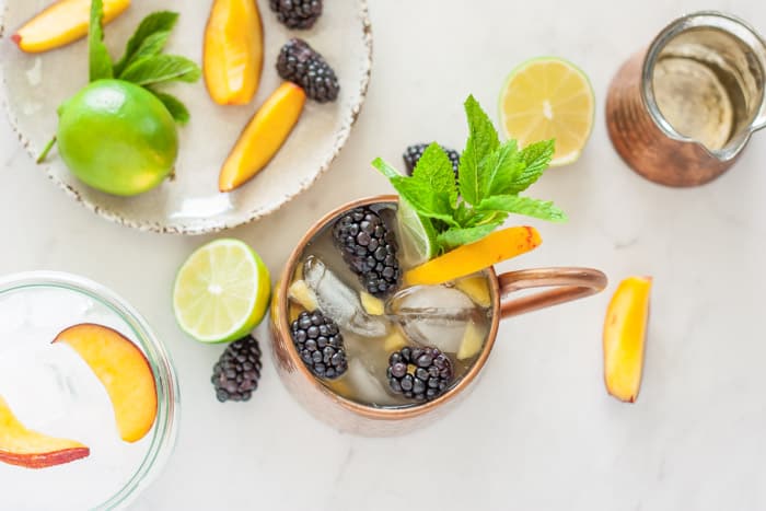 Copper mug with peach, blackberry, and mint.