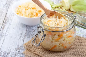 A jar of fermented sauerkraut with carrots.