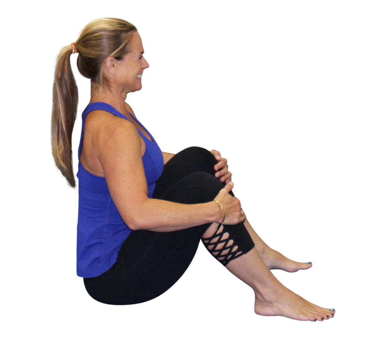 Woman in blue tank top sitting cross-legged.