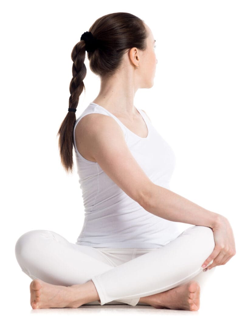 Woman in white seated with legs crossed.