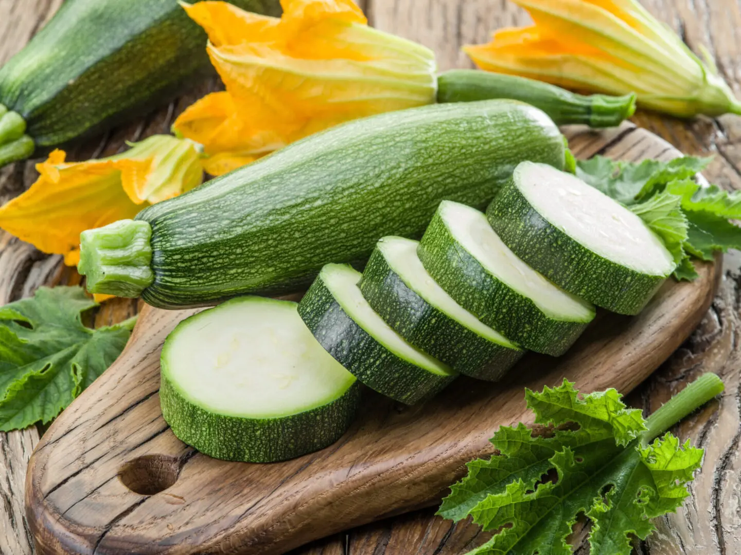 Sliced zucchini on a wooden board.