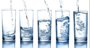 Five glasses filling with water.