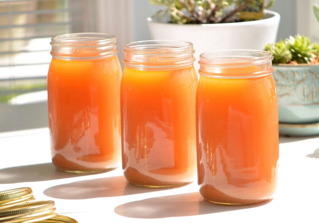 Three jars of homemade orange juice.