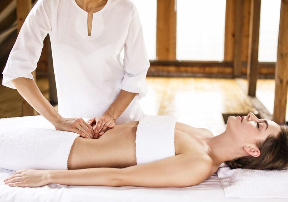 A woman is getting her breast checked by an esthetician.