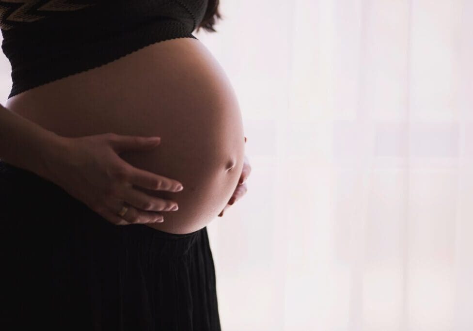 Pregnant woman holding her belly.