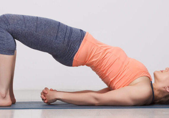 Woman doing a bridge pose on a mat.