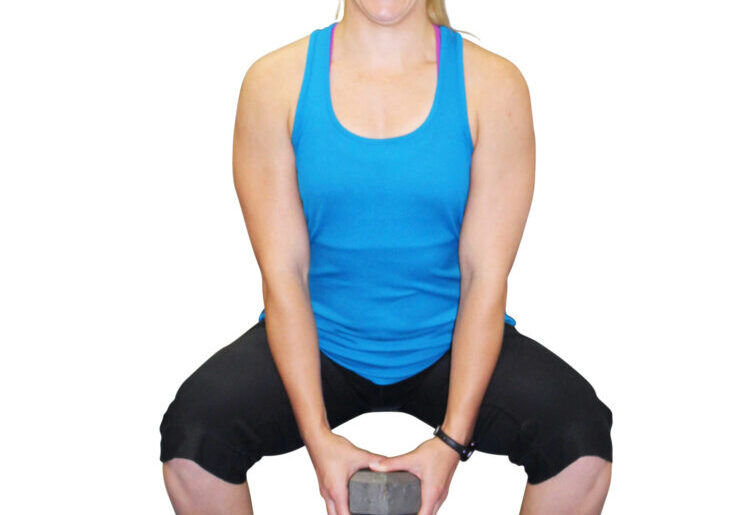 Woman squatting with dumbbell in hand.