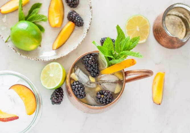 Copper mug with peach, blackberry, and mint.