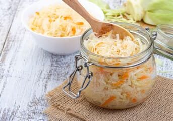 A jar of fermented sauerkraut with carrots.