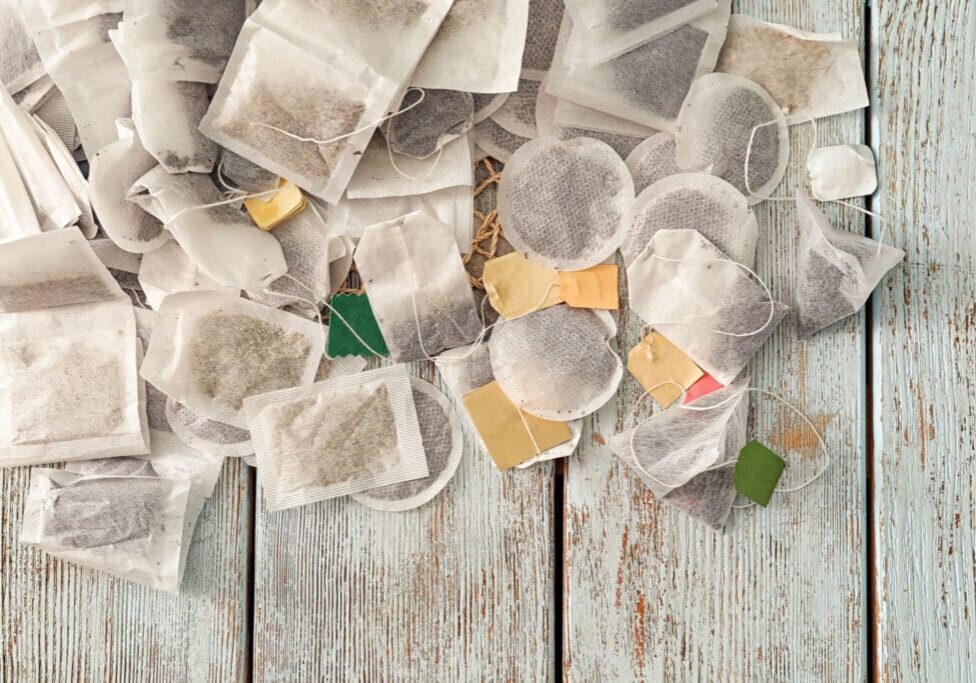 Used tea bags on a wooden table.